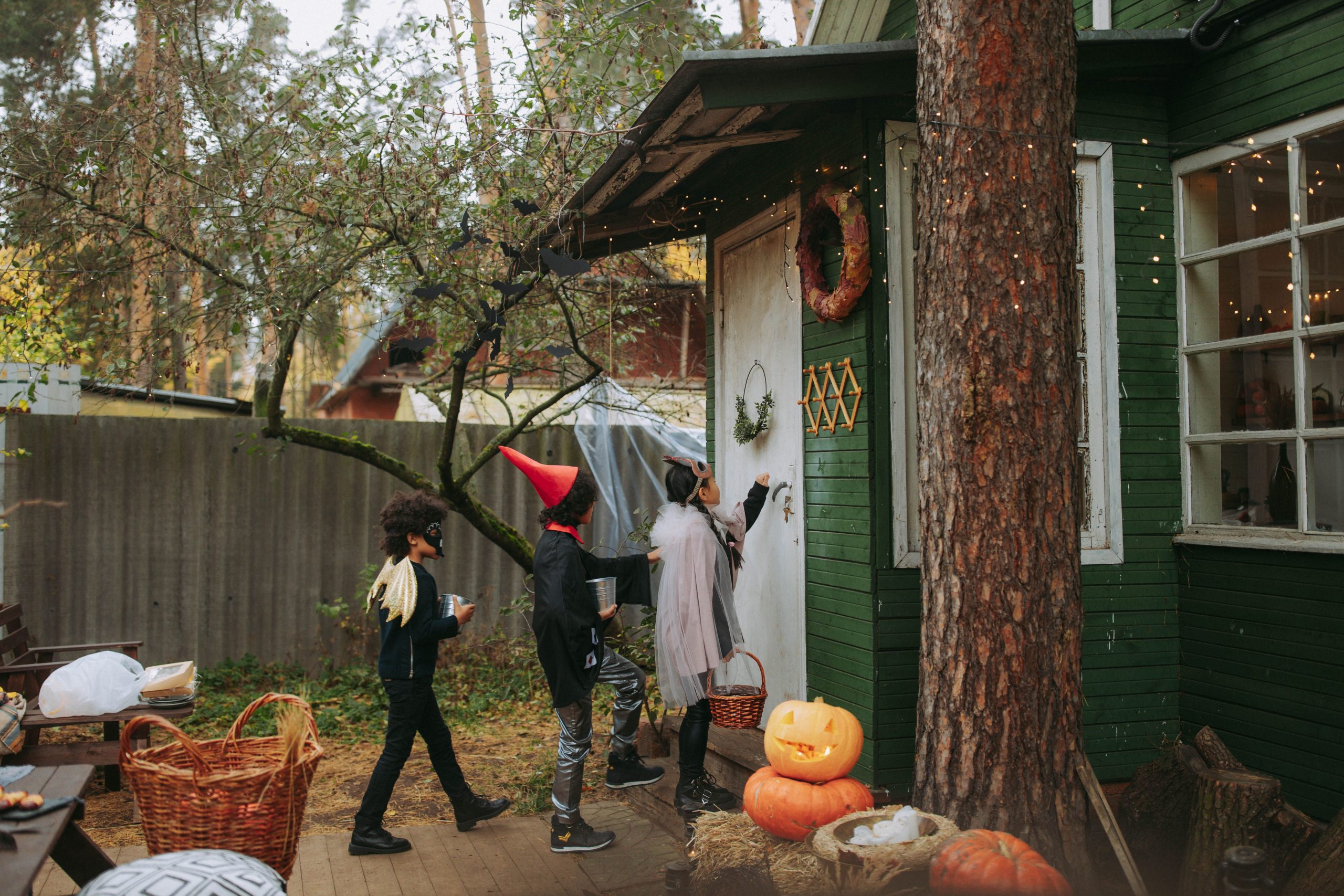 Children in Halloween costumes walking safely with parents at dusk
